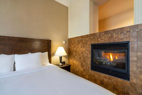 um quarto de hotel com uma cama e uma lareira em Comfort Inn & Suites Surrey em Surrey