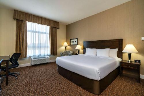 a hotel room with a large bed and a desk at Comfort Inn & Suites in Surrey