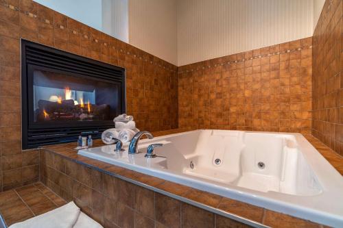 a large white tub in a bathroom with a fireplace at Comfort Inn & Suites Surrey in Surrey
