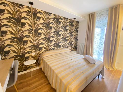 a bedroom with a bed and a wall with plants at b&b Stadium room & suite in Crotone