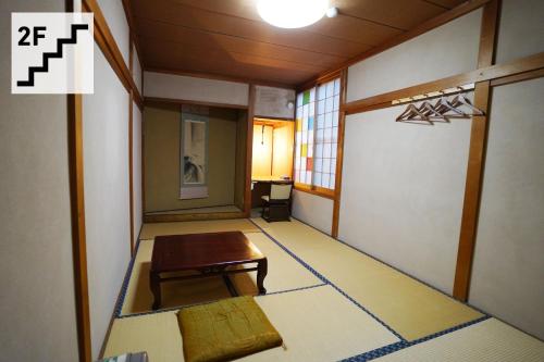 a room with a table and a bench in it at Hostel Murasaki in Takayama
