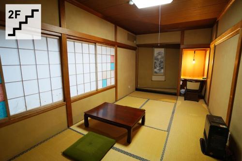 a room with a table in a room with windows at Hostel Murasaki in Takayama