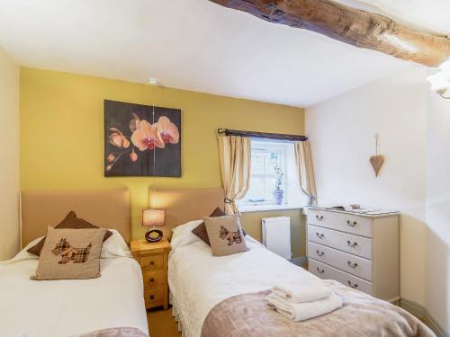 um quarto com 2 camas e uma cómoda e uma janela em The Smithy - 13920 em Hawnby