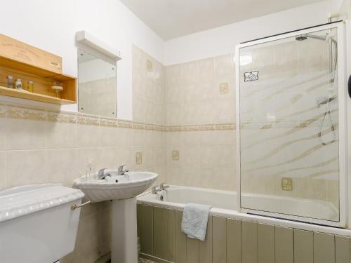 uma casa de banho com um lavatório e um chuveiro em The Smithy - 13920 em Hawnby