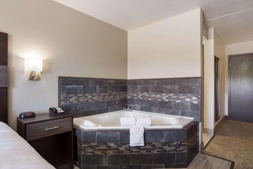 a hotel room with a tub and a bed at Rodeway Inn Branson, Brick House in Branson