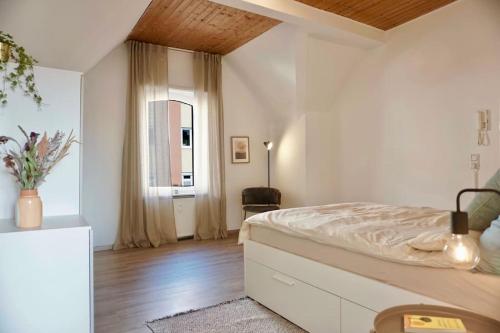 a white bedroom with a bed and a window at NEU I moderne zentrale Wohnung I Netflix I 4 Gäste in Andernach