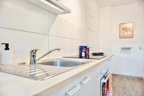 een keuken met een wastafel en witte muren bij NEU I moderne zentrale Wohnung I Netflix I 4 Gäste in Andernach