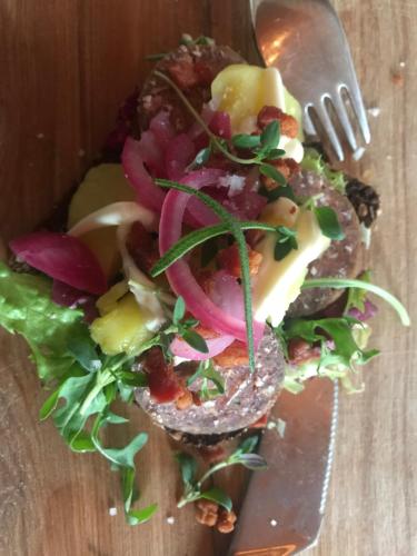 a plate of food with a fork and a salad at Bremsmaj Farm Holiday in Kværs