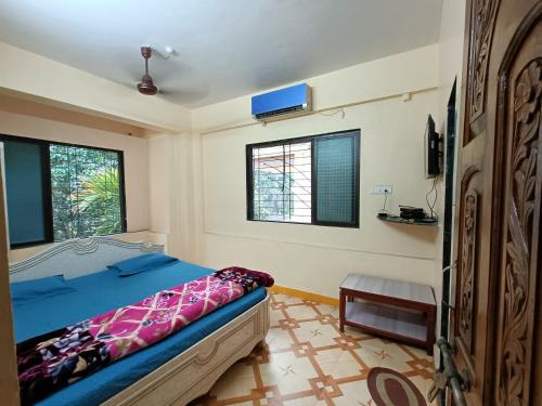 1 dormitorio con 1 cama y 2 ventanas en Sahil Residency, en Murud