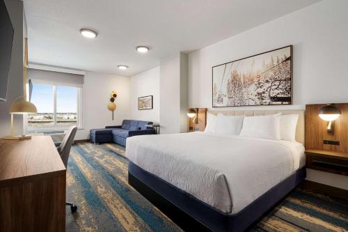 La Quinta Inn & Suites by Wyndham Denver Parker في باركر: غرفة فندقية بسرير كبير واريكة