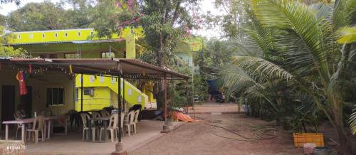 a yellow food truck parked in a yard with trees at UK homestay in Malvan