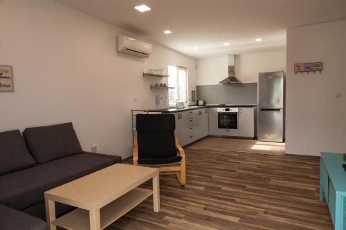 Krapets Holiday Villas في كرابيتس: غرفة معيشة مع أريكة ومطبخ