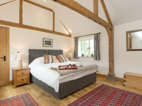 a bedroom with a large bed and a wooden floor at The Calf Shed-ukc2113 in Royal Wootton Bassett