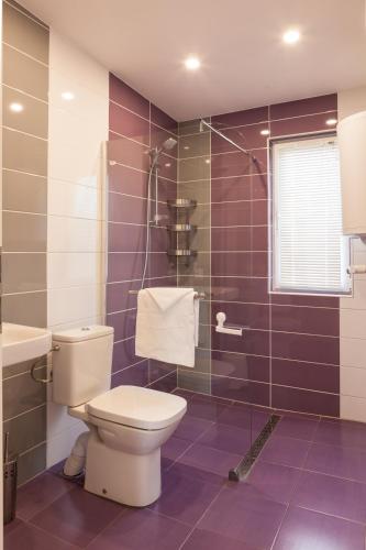 a purple bathroom with a toilet and a sink at Krapets Holiday Villas in Krapets