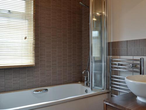 a bathroom with a tub and a sink at Kingfisher Lodge in Gorleston-on-Sea
