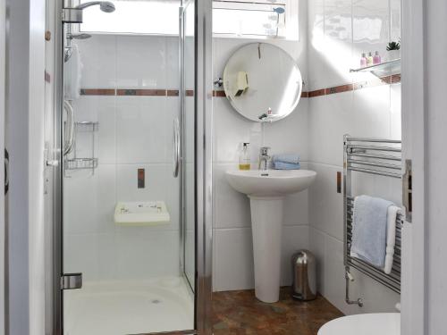 a bathroom with a shower and a sink and a mirror at Sandstell Point in Berwick-Upon-Tweed