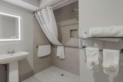 a bathroom with a sink and a shower with towels at Quality Inn & Suites in Aiken