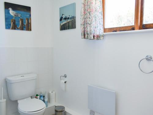 a white bathroom with a toilet and a window at The Plough Shed- 24493 in Compton