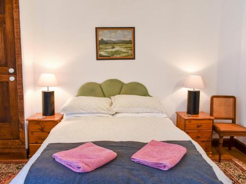 a bedroom with a bed with two pink towels on it at The Plough Shed- 24493 in Compton