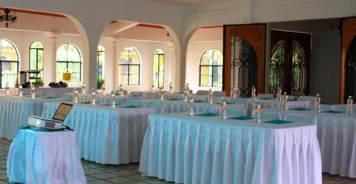 a room filled with tables with white tablecloths at Hotel Oaxtepec in Oaxtepec