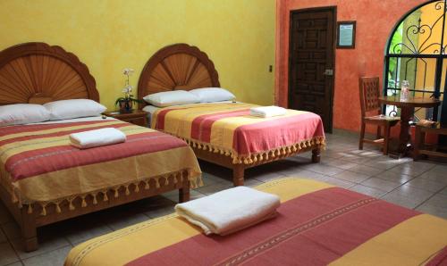 a hotel room with two beds with towels on them at Hotel Oaxtepec in Oaxtepec