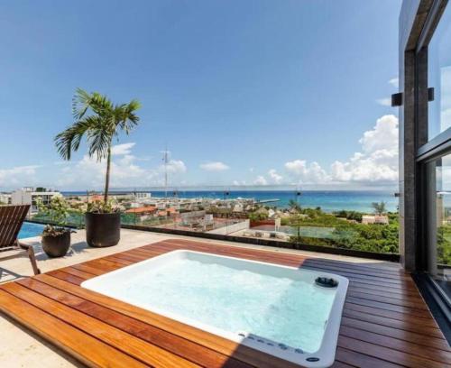 a hot tub on a deck with a view of the ocean at Luxury Studios On The 5th avenue Ocean View Rooftop I By Yeah in Playa del Carmen