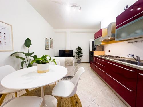 kuchnia z białym stołem i białymi krzesłami w obiekcie Litta's flat in Affori - 3 mins walk from MM3 w Mediolanie