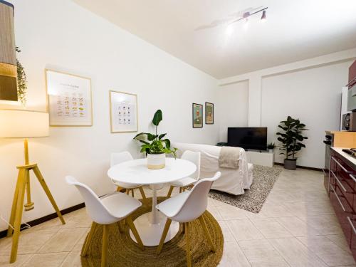 uma sala de estar com uma mesa branca e cadeiras em Litta's flat in Affori - 3 mins walk from MM3 em Milão