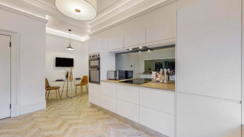 a kitchen with white cabinets and a dining room at 69 St Georges Mansions in Glasgow
