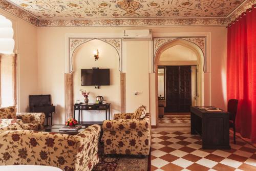 a living room with a couch and a table at Mundota Fort And Palace in Pachār