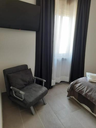 a bedroom with a chair and a bed and a window at Nautica Tarello - Casa Ena BeB in Viverone