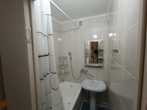 La salle de bains blanche est pourvue d'un lavabo et de toilettes. dans l'établissement Lux Home на Амурской, à Öskemen