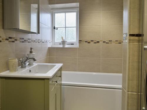 a bathroom with a sink and a bath tub at Farm Cottage in Margate