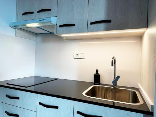 a kitchen with a sink and blue cabinets at Apartamentos Turísticos Magallanes I in San Pedro del Pinatar