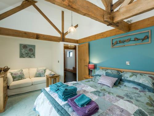 a bedroom with a large bed and a couch at The Cow Shed in Horning