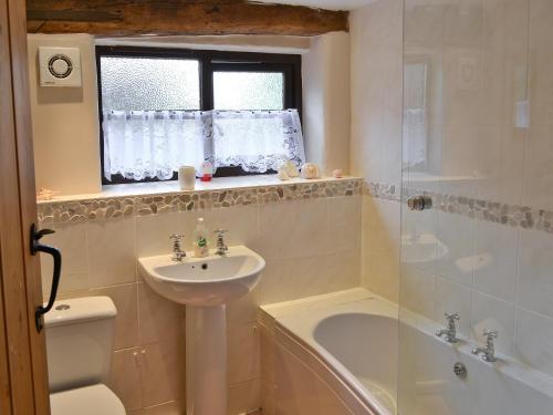 uma casa de banho com um lavatório, um WC e uma banheira em Saracens Retreat em Thurgarton