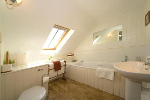 a bathroom with a toilet and a sink and a tub at Brook Cottage in Baltonsborough