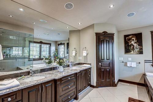 a large bathroom with two sinks and a large mirror at Westmount River Inn in Calgary