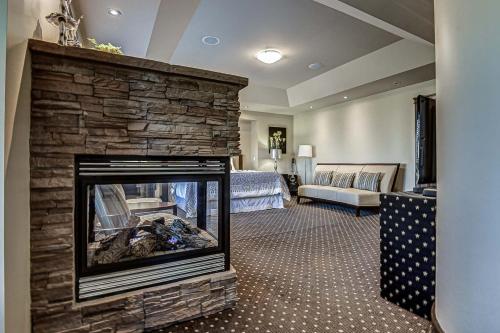a living room with a fireplace with a stone wall at Westmount River Inn in Calgary