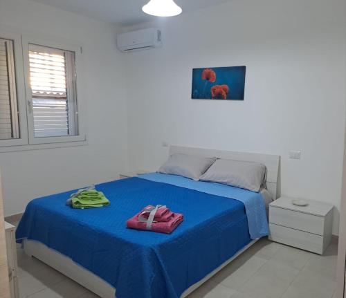 una camera da letto con un letto con lenzuola blu e una finestra di Casa Istadi a Maracalagonis