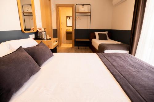 a hotel room with two beds and a mirror at Urla 1867 Hotel in Urla