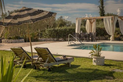 two lawn chairs and an umbrella next to a swimming pool at Queen Bee Residence in Minia