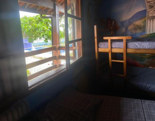 a room with a window with a bed and a ladder at Colônia Virtual Net in Itanhaém