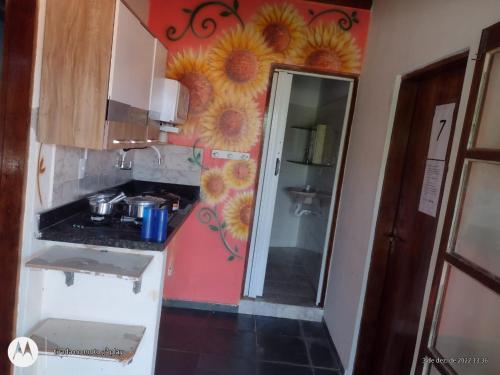 a kitchen with sunflowers painted on the wall at Colônia Virtual Net in Itanhaém