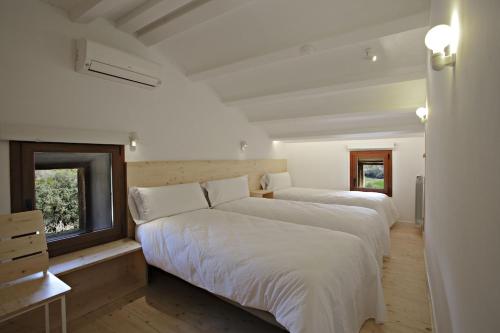 a bedroom with two beds and a window at Masoveria la Boba in Vilanova de la Aguda