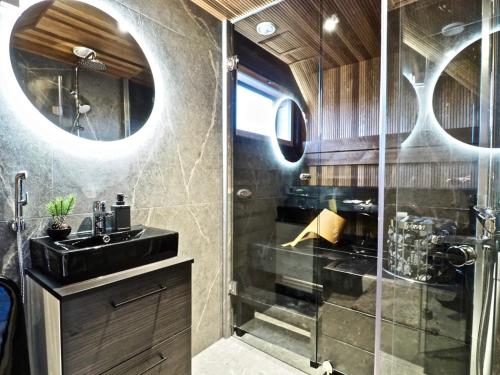 uma casa de banho com uma cabina de duche em vidro e um lavatório. em Levillas Levin Tuulahdus em Sirkka
