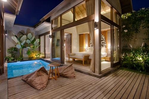 a room with a swimming pool and a bedroom at Taman Dharmawangsa Suites in Nusa Dua