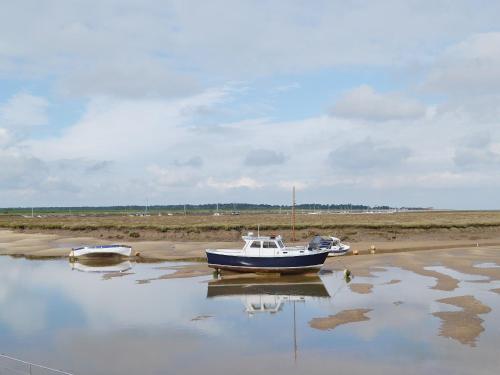 a boat sitting in the water on the beach at Crown And Anchor in Wells next the Sea