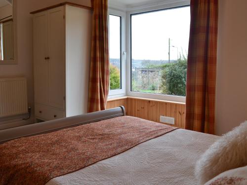a bedroom with a bed and a large window at Haulfryn Cottage in Menai Bridge