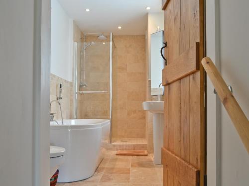 een badkamer met een bad, een toilet en een wastafel bij Haulfryn Cottage in Menai Bridge